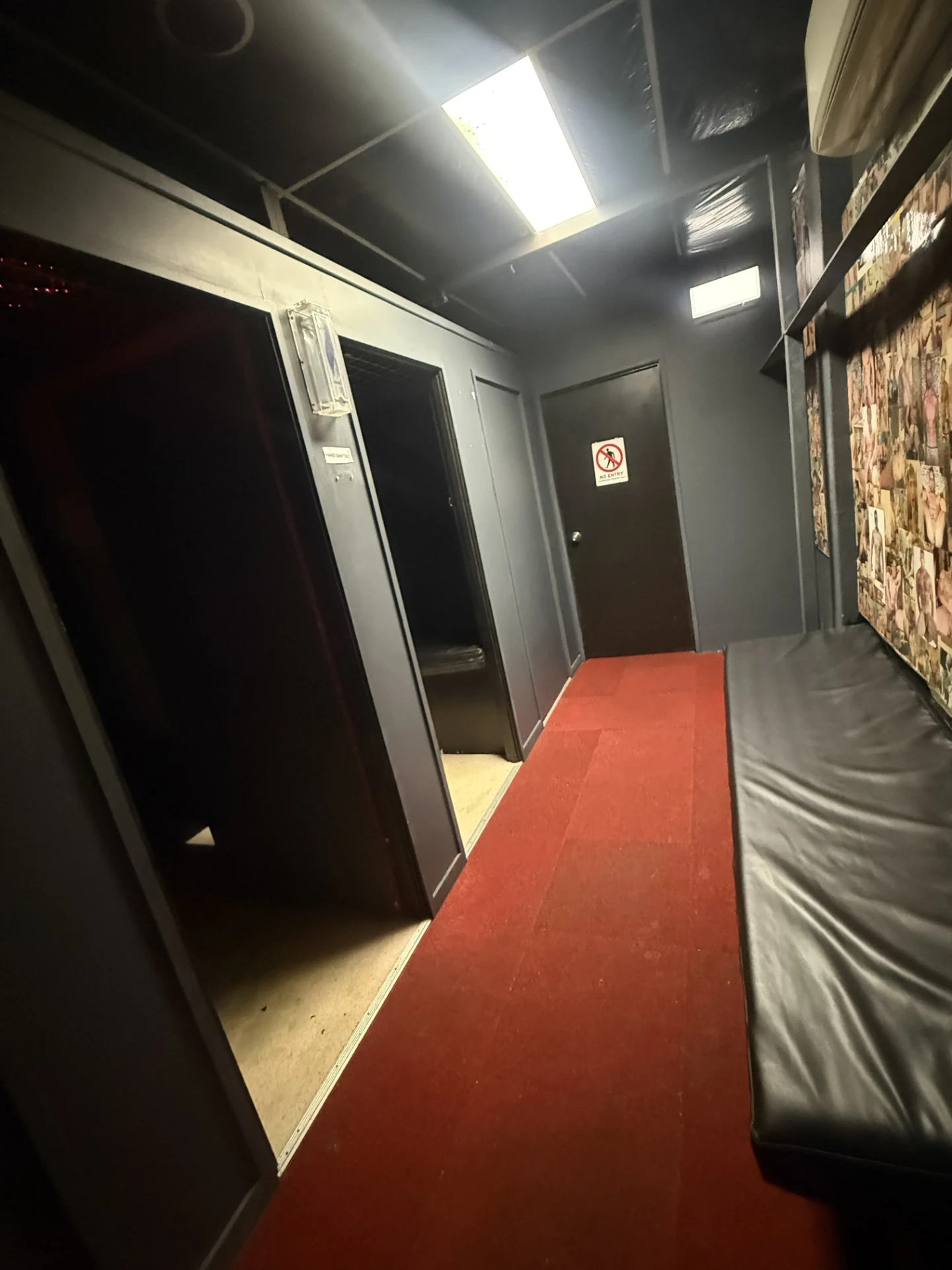 Red-carpeted corridor at Cruise Club Cairns lined with private room doors and bench seating