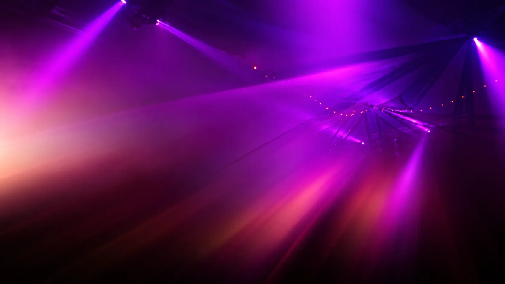 Purple and magenta beams sweeping across the darkened floor at Cruise Club Cairns